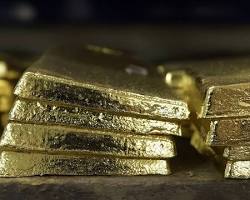 A stack of Perth Mint gold bars on a table.